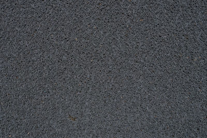Detailed view of a gray synthetic doormat showcasing its fiber texture